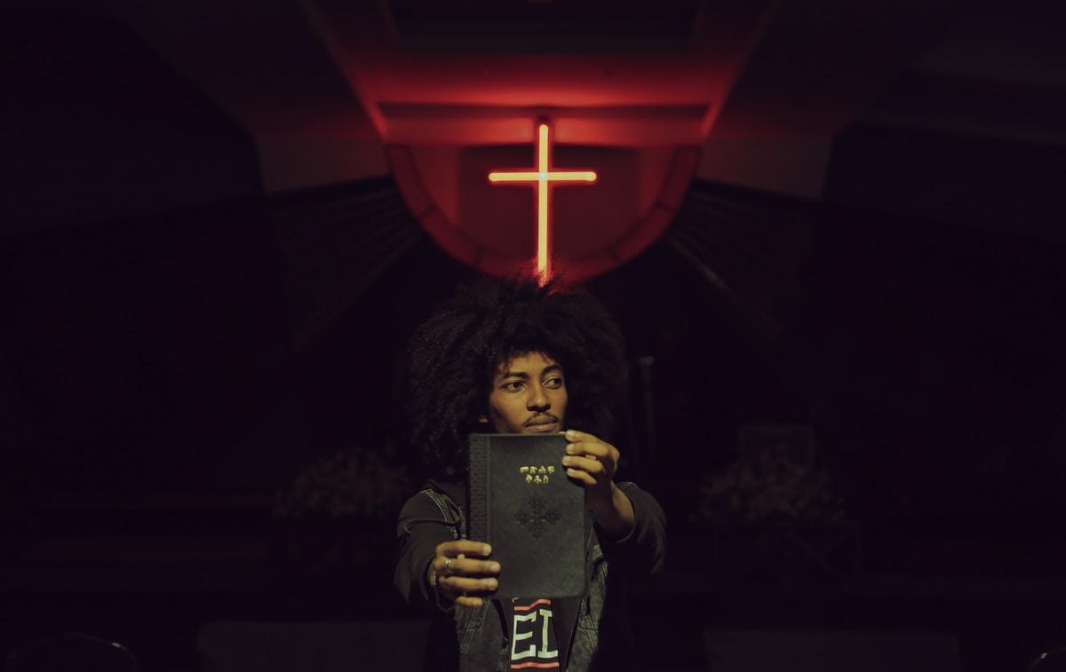 man in black top holding book